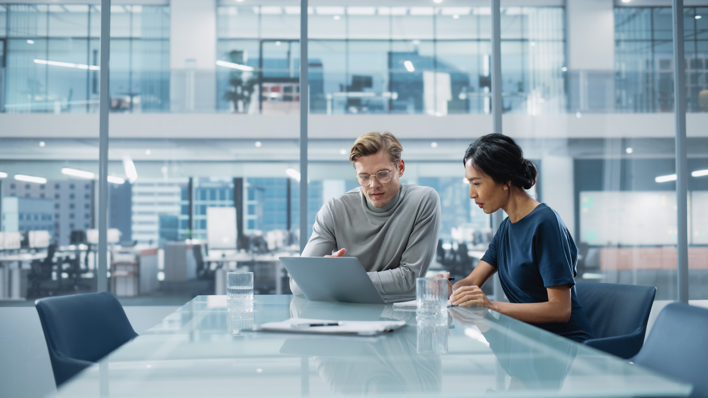 Man and woman at a computer in an office environment